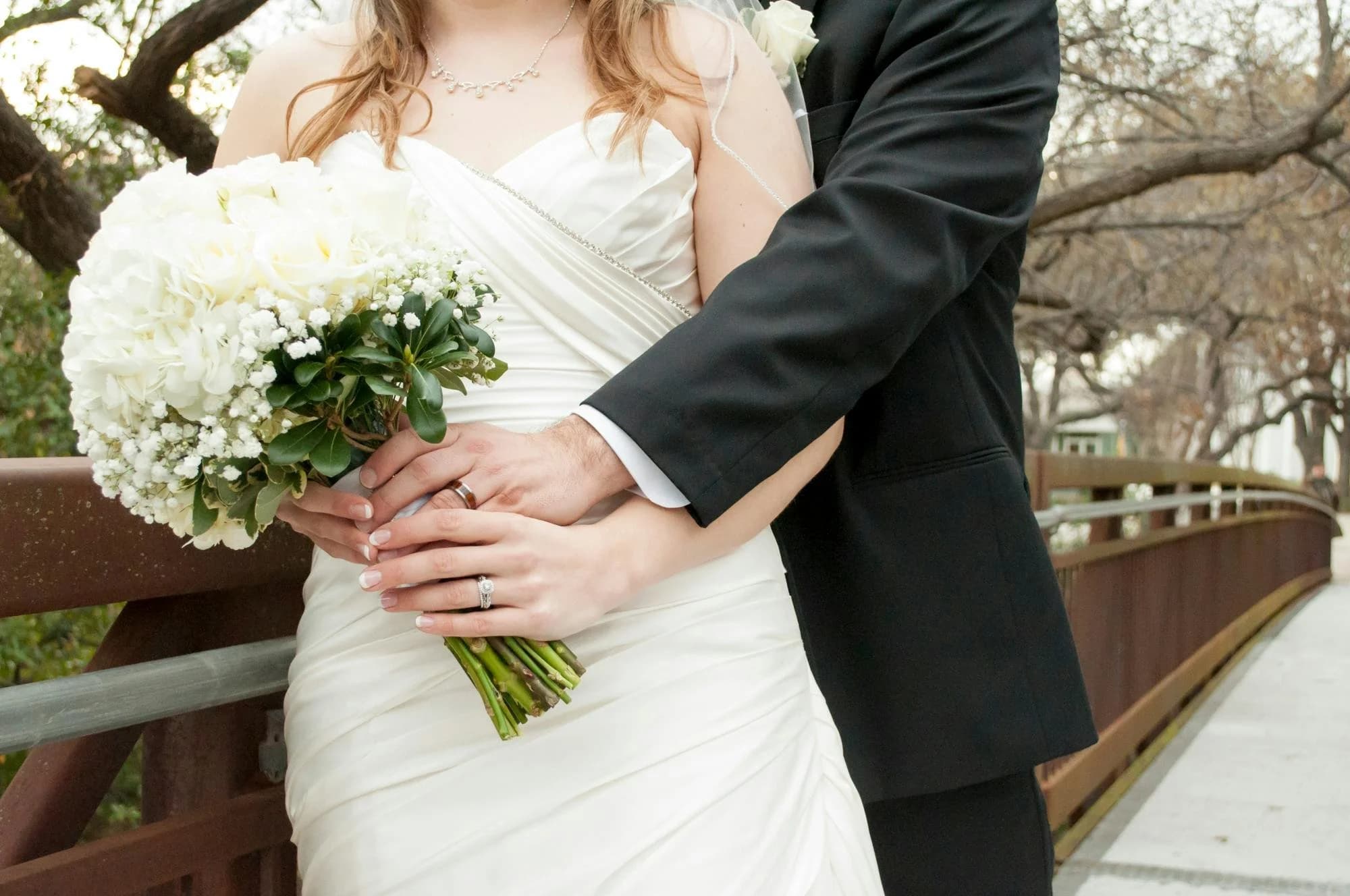 Bride and groom beside a wedding car