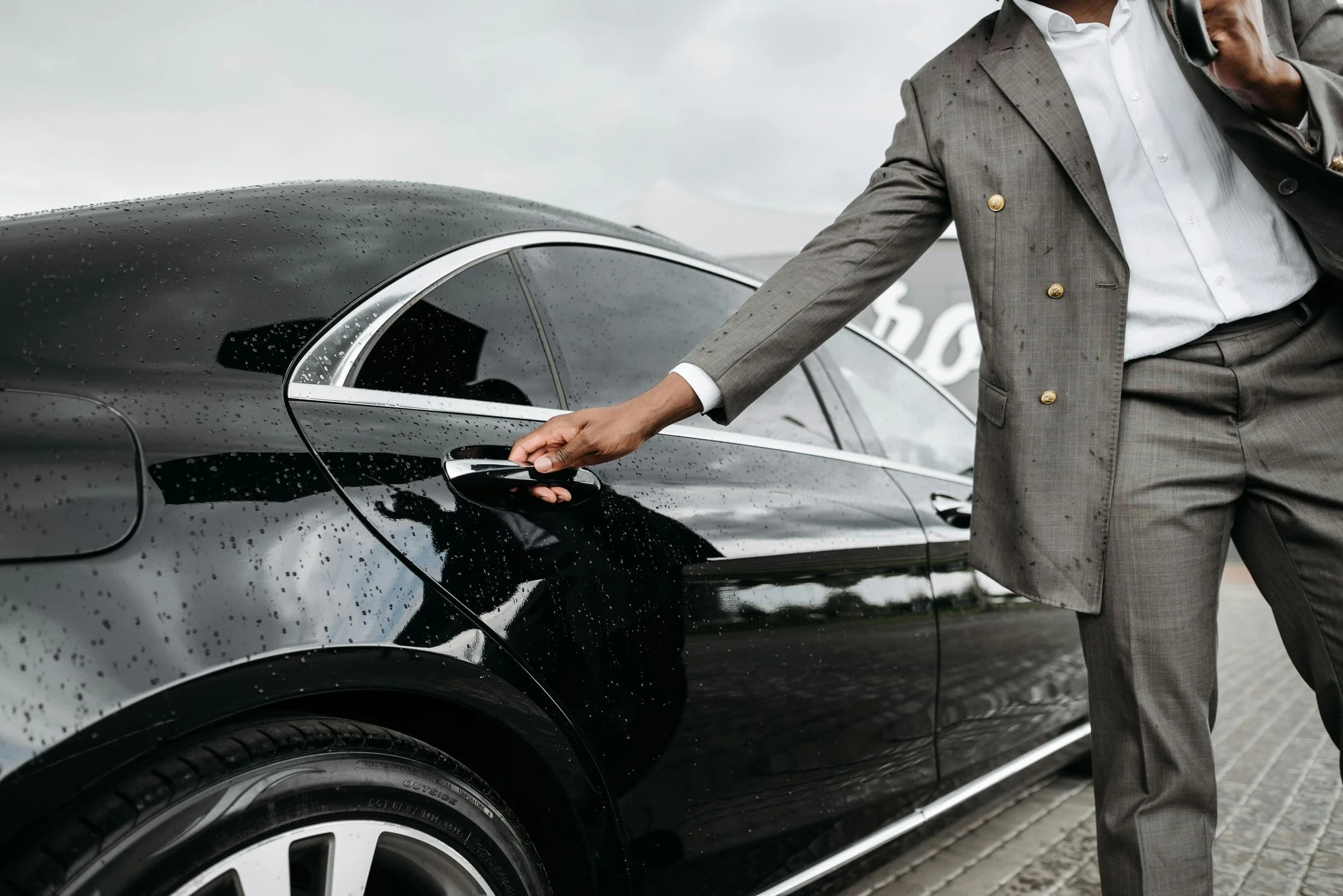 A SPLT chauffeur opening a car door